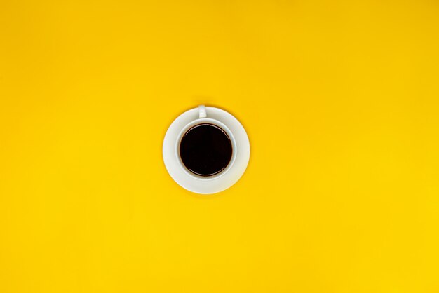 Cup of coffee on yellow surface