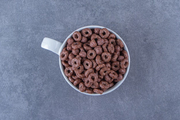 Free photo a cup of corn rings , on the blue background.