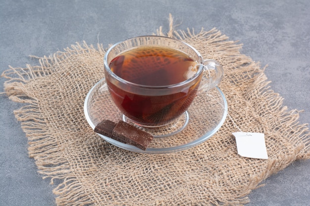 A cup of delicious aroma tea on sackcloth .