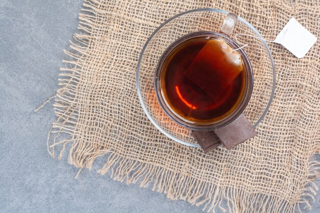 A cup of delicious aroma tea on sackcloth .