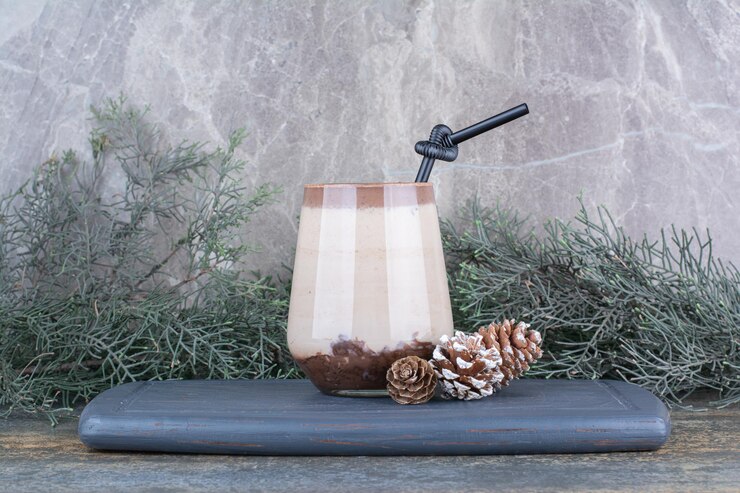 Free Photo a cup of delicious drink with pinecones and straw on dark board. high quality photo