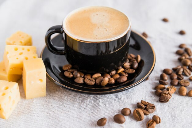 Cup of drink near cheese on table