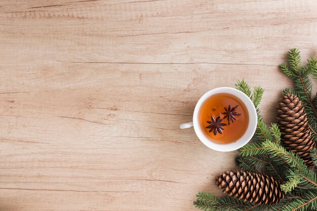 Cup of drink near coniferous twigs and snags