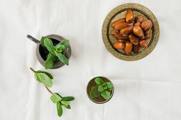 Tazza di bevanda vicino al lanciatore e frutta secca