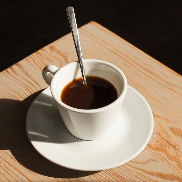 Cup of fresh coffee on desk in coffee shop