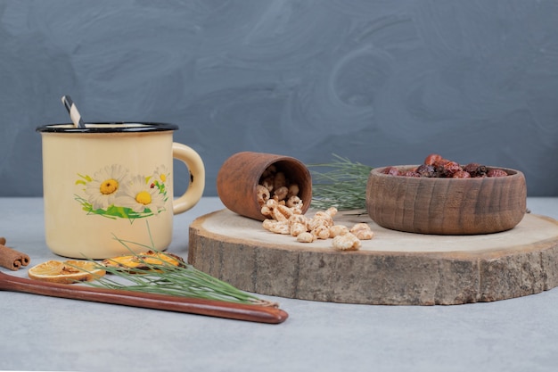 Cup of herbal tea, dried cranberries and sweets on marble table. High quality photo