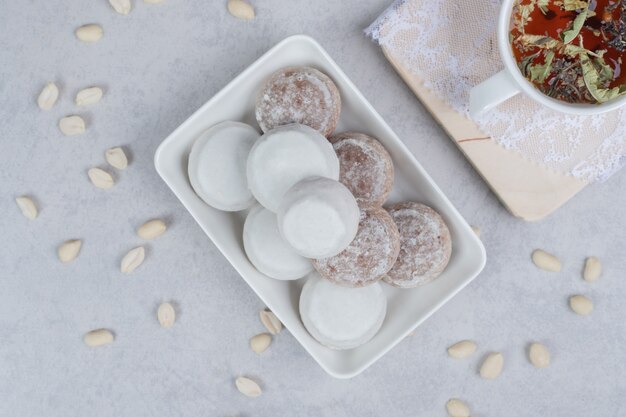 Cup of herbal tea, and plate of various cookies on wooden board. High quality photo