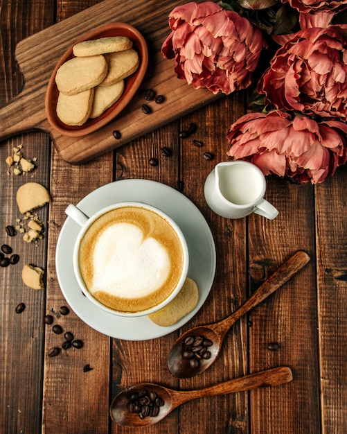 Foto gratuita tazza di cappuccino caldo con biscotti di pasta frolla