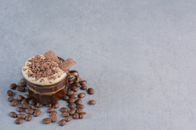 Tazza di cioccolata calda e chicchi di caffè su pietra.