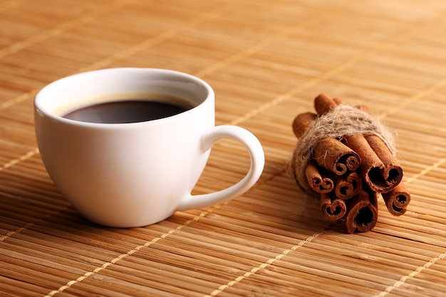 Cup of hot coffee and cinnamon sticks