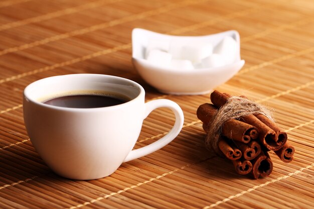 Чашка горячего кофе и палочки корицы