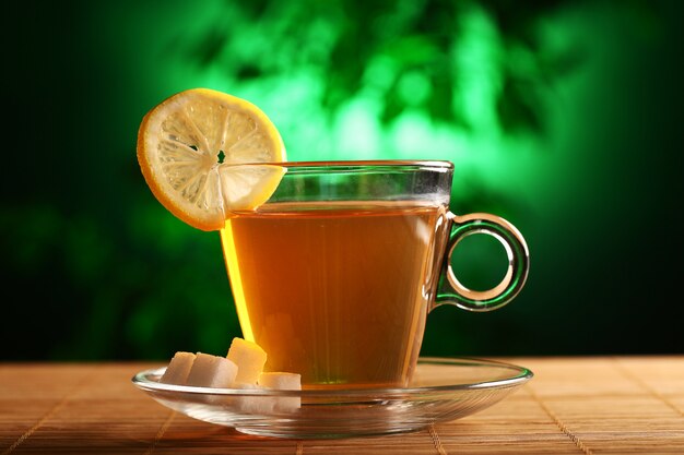Чашка горячего зеленого чая с сахаром и лимоном