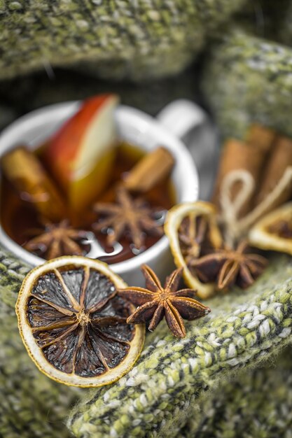 Cup of hot tea with cinnamon sticks and delicious dried citrus fruit