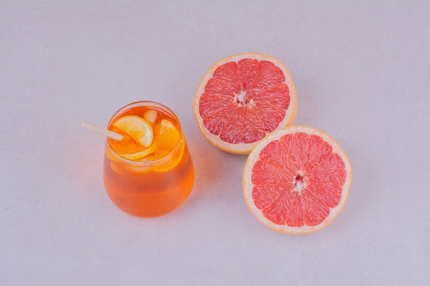 中に柑橘系の果物が入ったジュースのカップ