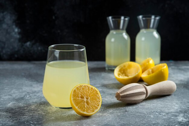 レモンと木製のリーマーのスライスとレモネードのカップ。