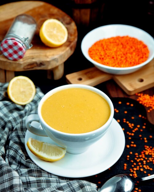 A cup of lentil soup served with lemon