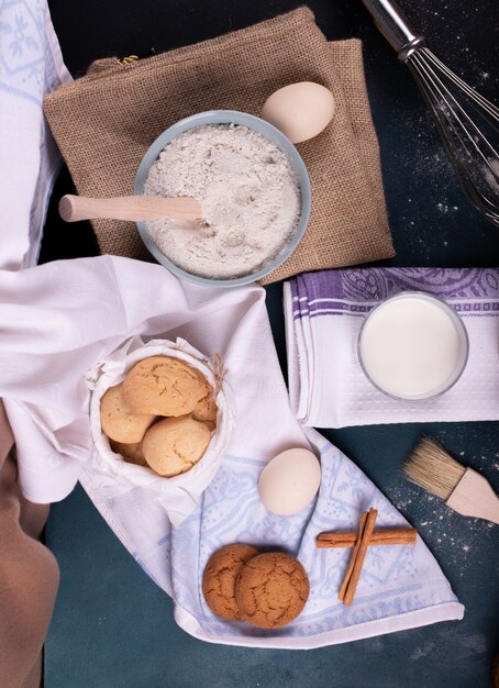 Cup of milk with jar of biscuits and flour