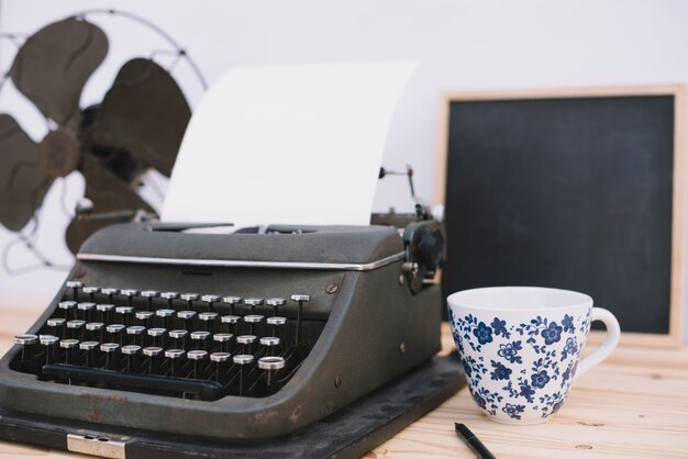 Cup near retro typewriter