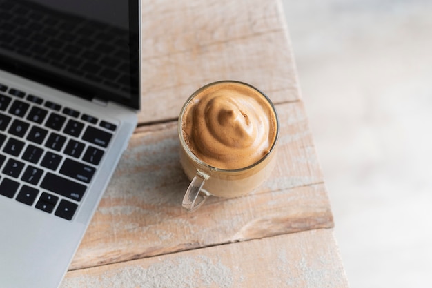 Бесплатное фото Чашка кофе рядом с ноутбуком