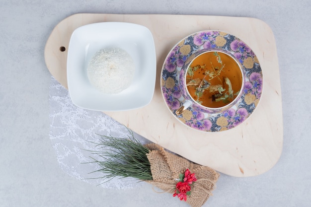 Бесплатное фото Чашка чая и кокосовое печенье на деревянной доске с рождественским украшением. фото высокого качества