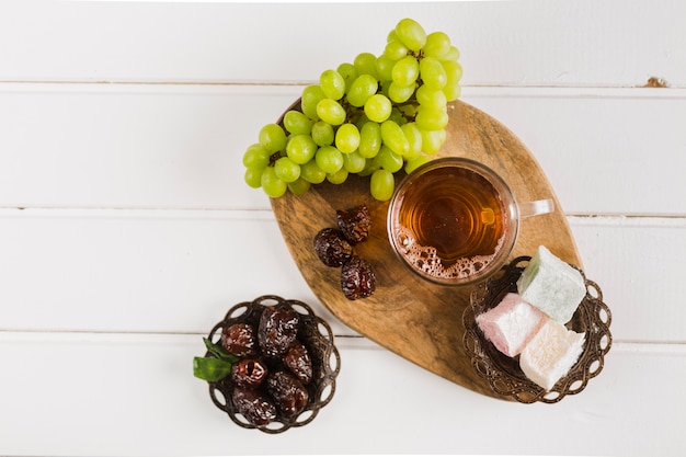Бесплатное фото Чашка чая с восточными сладостями и виноградом