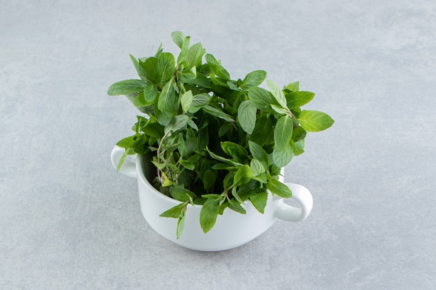 A cup of organic mint , on the marble.