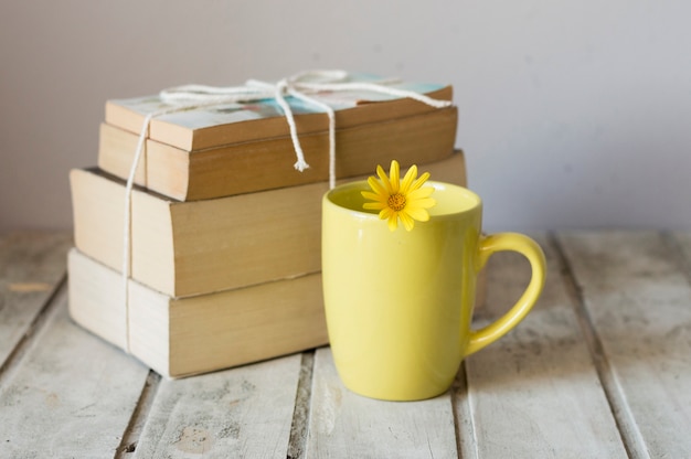 Cup next to pile of book