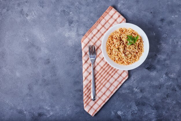 A cup of spaghetti in tomato sauce.