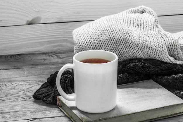 冬のセーター、古い本、冬、秋、クローズアップと美しい木製の背景にお茶のカップ