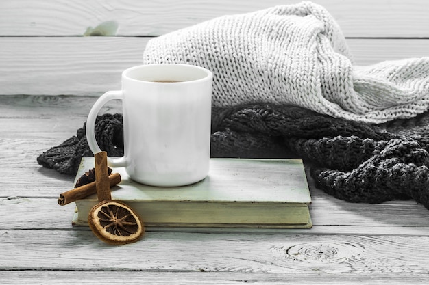 冬のセーター、古い本と美しい木製の壁にお茶を一杯
