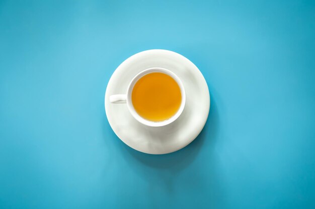 Cup of tea on blue background isolated flat lay