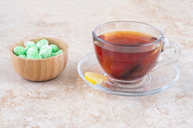 A cup of tea and a bowl of mint candies 