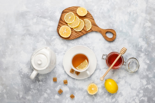 A cup of tea,brown sugar,honey and lemon on concrete  . Top view, copy space