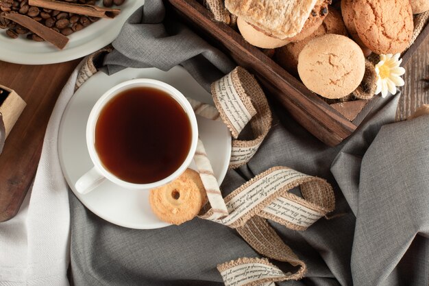 A cup of tea and butter cookies tray. top view