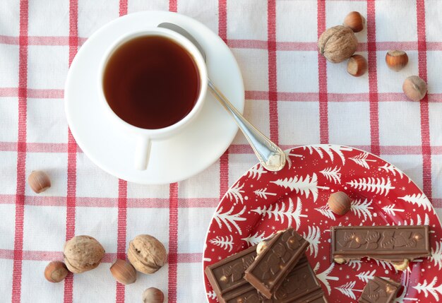 赤いプレートの紅茶とチョコレートのカップ。