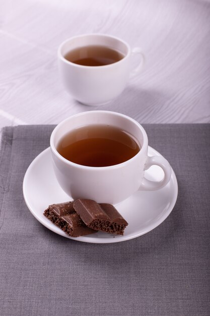 Cup of tea and chocolate with light background