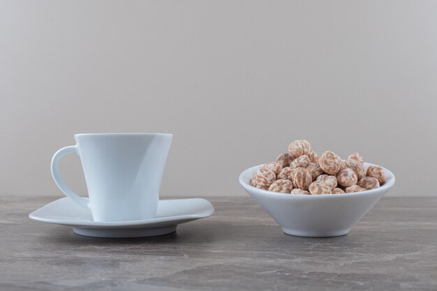 A cup of tea and confectionery on the marble surface