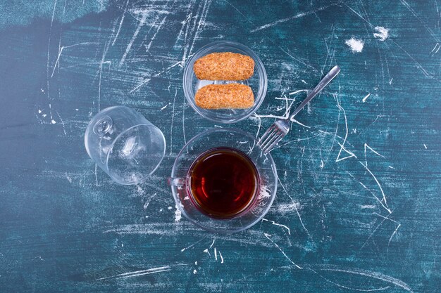 A cup of tea and cookies on a gray surface