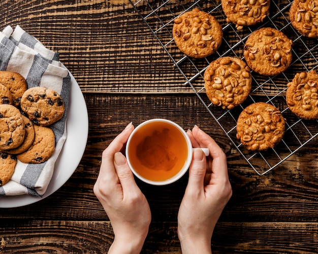 Foto gratuita tazza di tè e biscotti deliziosi sul tavolo