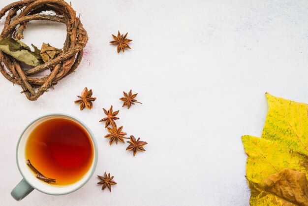 Cup of tea among flowers and leaves