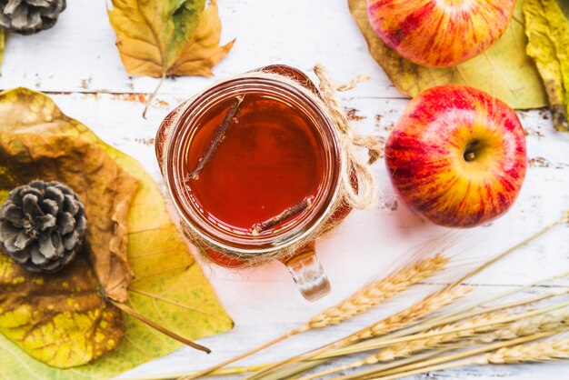 Cup of tea among leaves and wheat