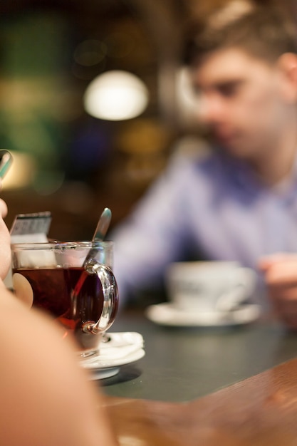 Cup of tea near blurred man