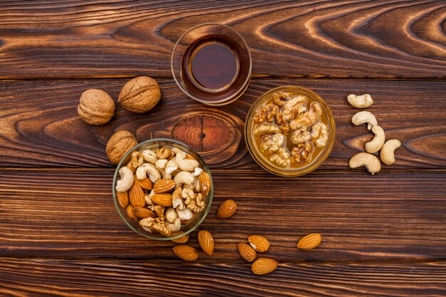 Cup of tea near set of fresh nuts in saucers