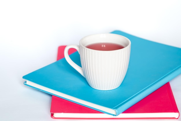 Free photo a cup of tea and notebooks on a white background isolated copy space