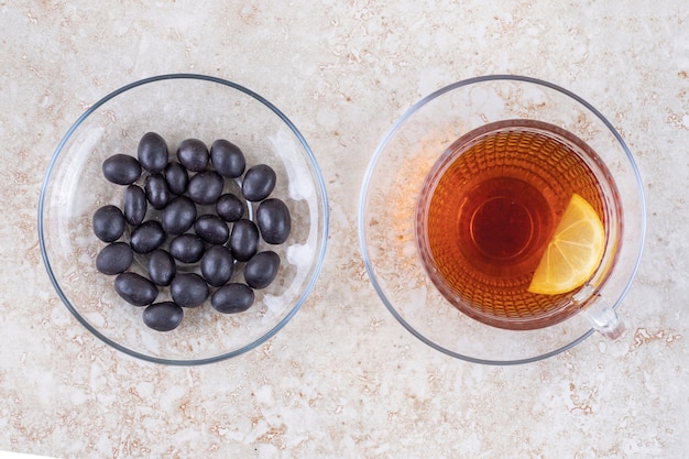 Free photo a cup of tea and a serving of candy balls