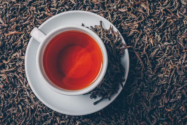 Cup of tea on a tea herbs background. top view.