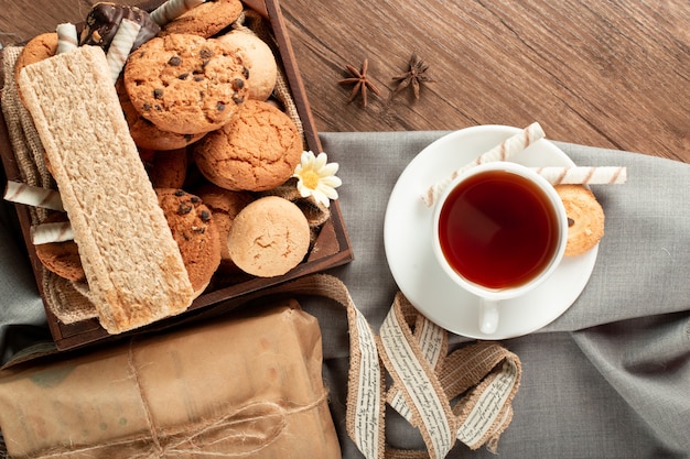 A cup of tea with biscuits tray around. Top view