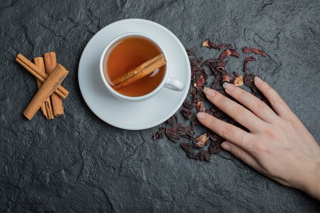 A cup of tea with cinnamon sticks and infusion . 