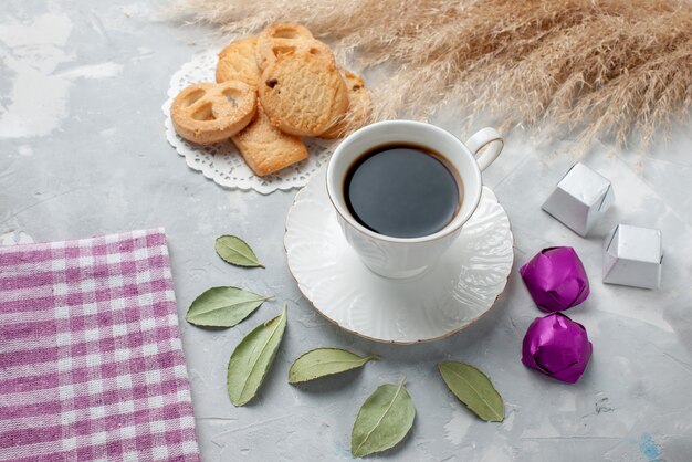 cup of tea with delicious little cookies chocolate candies on light floor cookie biscuit sweet tea sugar