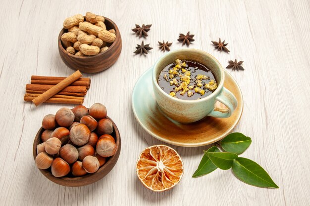 cup of tea with different nuts on white